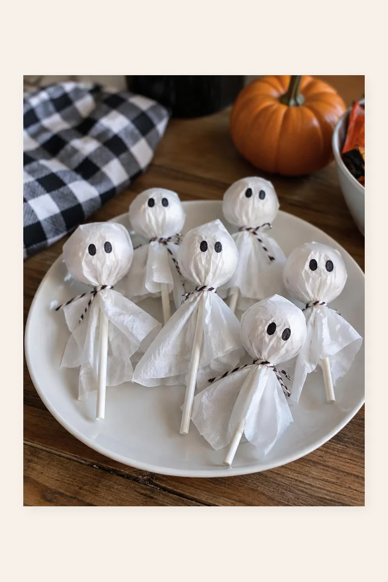 Ghost Lollipops craft with round lollipops wrapped in white tissue paper with drawn-on eyes